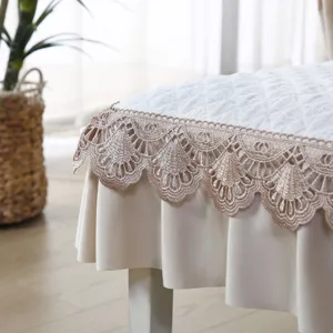 Detailed close-up view of white quilted dining chair cover with elegant champagne lace border.