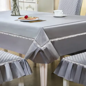 Ensemble housse de chaise et nappe en satin matelassé gris avec jolie bordure en dentelle.