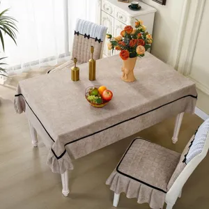 Dining table cloth and chair cover detail view showing beige fabric with elegant black bow and trim.