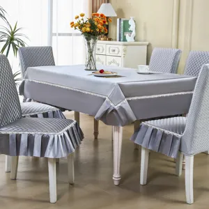 Détail de nappe et housse de chaise matelassées grises avec bordure en dentelle élégante.