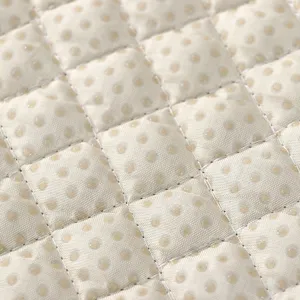 Primer plano de tela de cojín de silla acolchada en beige con puntos antideslizantes para el hogar