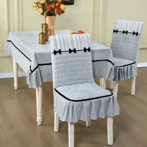 Detail view of grey quilted dining chair cover and matching tablecloth set with elegant black bows