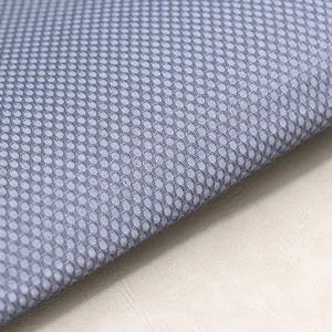 Vista detallada de la textura de tela de malla gris para textiles y fundas de sillas.