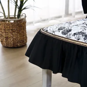 Housse de chaise de salle à manger matelassée avec jupe à volants noirs et imprimé floral.