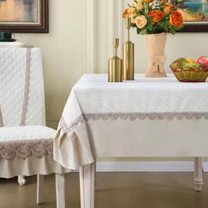 Detailed view of elegant white tablecloth and chair cover with delicate lace trim.