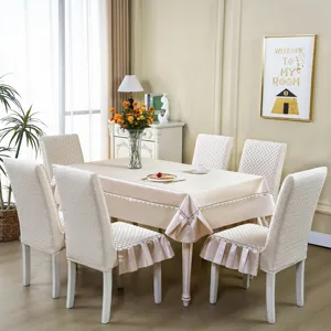 Vue détaillée des housses de chaise de salle à manger matelassées beiges et nappe assortie.