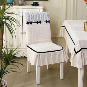Quilted dining chair cover with black bows, universal non-slip slipcover for home dining.