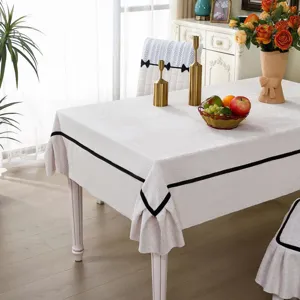 Elegant dining table cloth and chair cover set with stylish black trim for home decor.