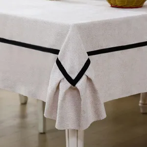 Detail shot of elegant beige tablecloth with stylish black border stripe for dining room decor.