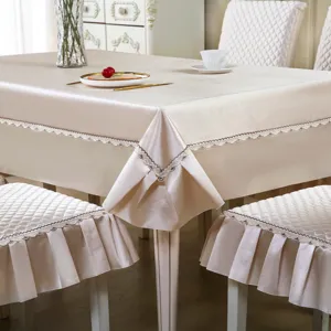 Ensemble de nappe et housse de chaise matelassé beige avec fine bordure en dentelle.