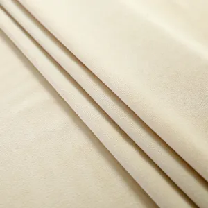 Detailed close up view of premium soft beige velvet fabric showing fine texture and quality.
