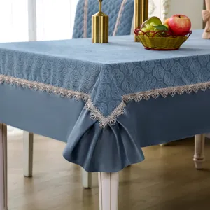 Elegant blue tablecloth and chair cover set with delicate lace trim for dining room decor.