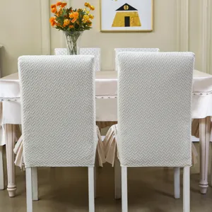 Vue détaillée de housses de chaise de salle à manger blanches matelassées et à motif texturé.