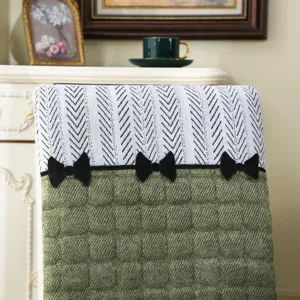 Detail view of the dining chair cover featuring green quilted fabric and elegant bows.