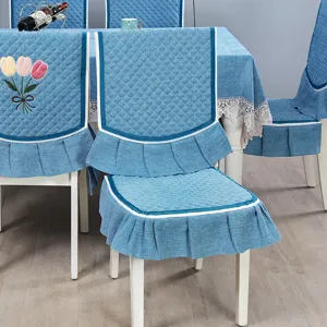 Set di coprisedie da pranzo e tovaglia trapuntati blu con ricamo di tulipani ed eleganti volant.