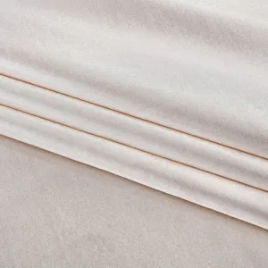 Gros plan sur un tissu satiné brillant montrant une fine texture tissée et des plis doux.