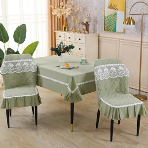 Green elastic dining chair cover set with elegant white lace and matching tablecloth decor.