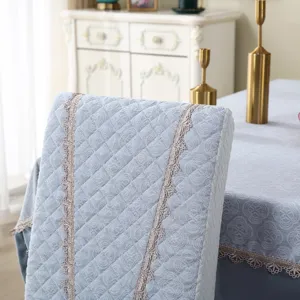 Quilted dining chair cover detail, light blue fabric with elegant lace trim, full wrap.