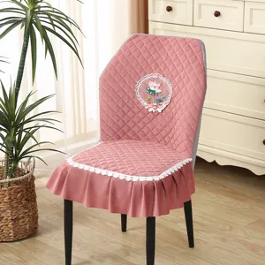 Pink quilted dining chair cover with lace skirt and embroidery design for home decor.