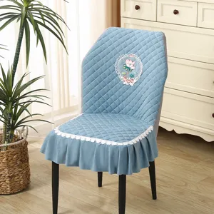 Blue quilted chair cover detail showcasing delicate lace trim and elegant floral embroidery decor.