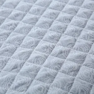Grey quilted chair cover fabric detail, soft textured diamond pattern cushion upholstery close-up