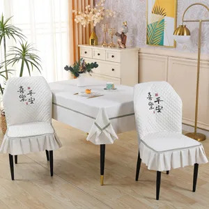 Quilted dining chair slipcover with ruffle skirt and Chinese embroidery detail, elegant home.