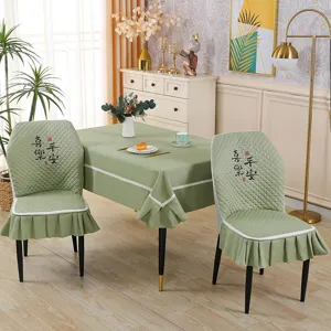 Green quilted dining chair cover with elegant skirt and Chinese embroidery detail.