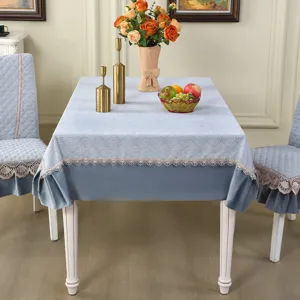 Detailed view of light blue quilted tablecloth and matching chair covers with elegant lace trim.