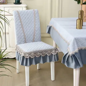 Elegant grey quilted dining chair cover with delicate lace ruffles, perfect for home decor.