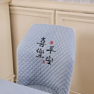 Quilted stretch dining chair cover detail, elegant blue fabric with Chinese embroidery pattern.