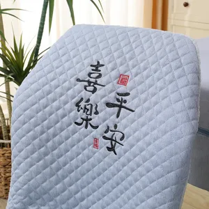 Detailed close-up of elastic dining chair cover featuring Chinese embroidery and soft quilted fabric.