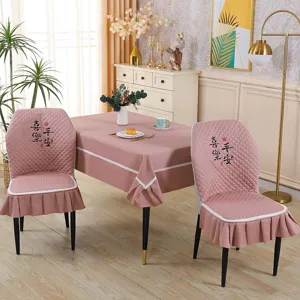 Pink quilted dining chair covers and tablecloth set with elegant white trim for home decor.