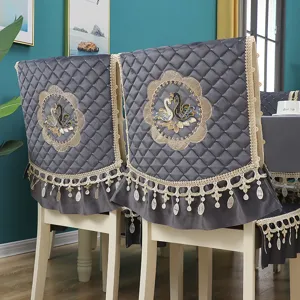 Grey velvet dining chair cover with quilted pattern, elegant lace trim and swan embroidery.