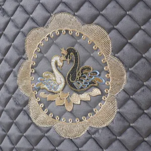 Detail shot of luxury grey velvet chair pad fabric featuring elegant swan embroidery.