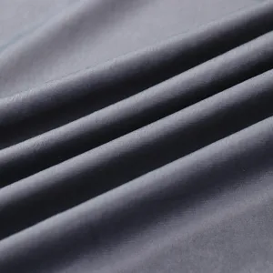 Close-up detail of soft dark grey Italian velvet fabric showing rich texture and drapes.
