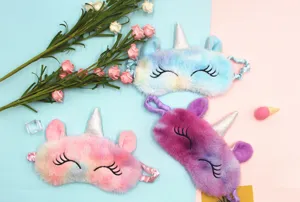 Detail view showing three colors of plush unicorn sleep masks with soft gradient fur texture