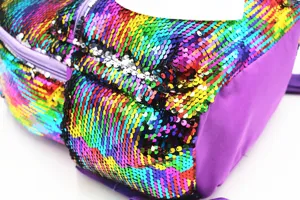 Macro view of vibrant rainbow sequins on a unicorn-themed student schoolbag for girls.