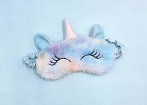 Close-up of soft plush unicorn sleep mask with gradient fur and silver horn detail