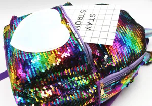 Close-up of colorful mermaid sequin backpack with heart patch and purple zipper detail