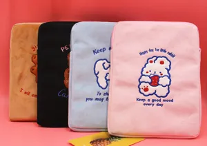 Detailed view of four colorful plush laptop sleeves with cute cartoon embroidery