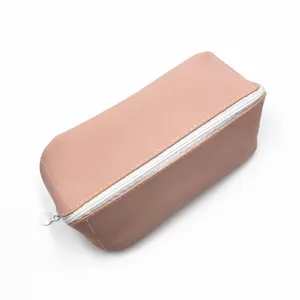 Gros plan d'une trousse en cuir PU rose avec fermeture éclair blanche et style minimaliste