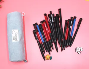 Detailed view of light blue corduroy pencil case with various pens on pink surface