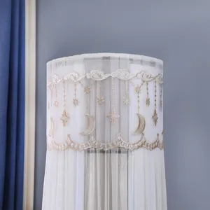 Detail view of gold star and moon embroidery on a white mesh cylindrical AC dust cover.