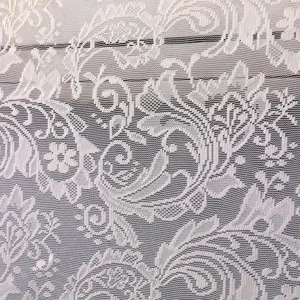 Dettaglio macro di tessuto in pizzo floreale bianco con intricati motivi a rete