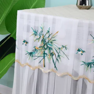 Détail de la broderie oiseaux et bambous sur une housse de machine à laver en résille