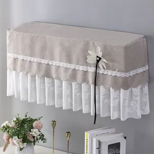 Vista dettagliata del copricondizionatore grigio con bordo in pizzo floreale bianco e un fiore