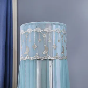 Close-up of decorative lace embroidery with moon and stars on a teal AC cover