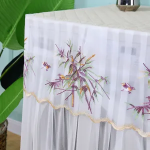 Gros plan sur les broderies de bambou et d'oiseaux d'une housse de machine à laver fine