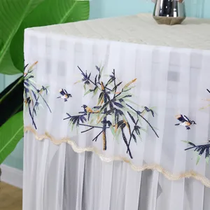 Détail de la housse de machine à laver en dentelle blanche avec broderie d'oiseaux