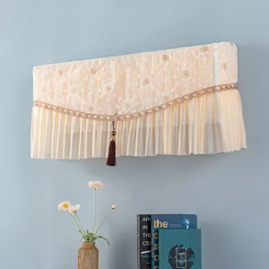 Dettaglio della copertura per condizionatore in pizzo beige con nappa